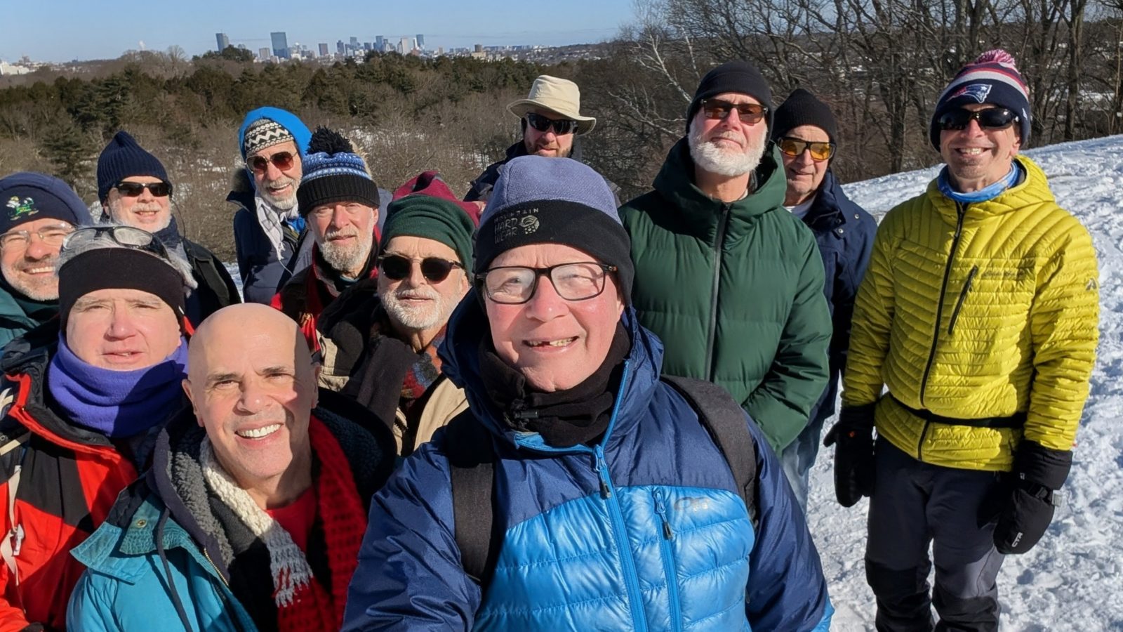 GayOutdoors members on a winter hike with the Boston skyline behind them