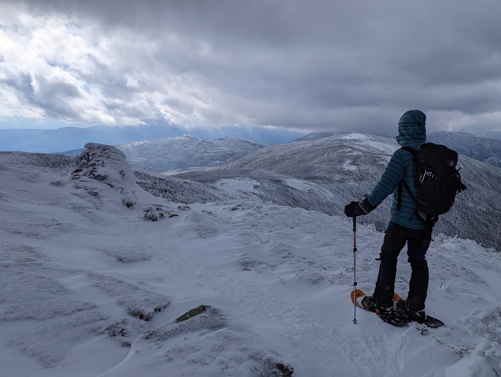 A GayOutdoors member on snowshoes looking out over snow-covered White Mountain ridges
