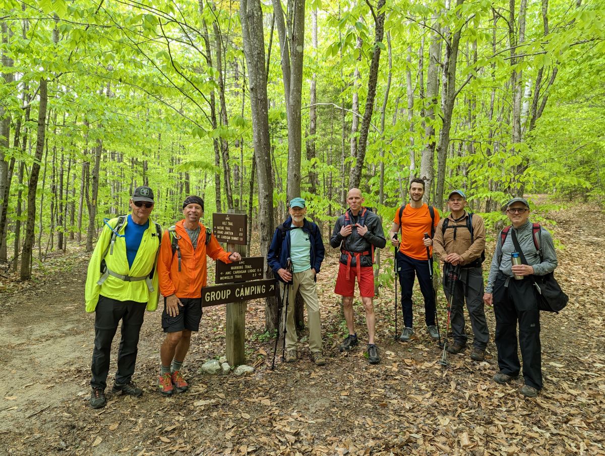 GayOutdoors members gathered at a trail junction signpost on a spring hike